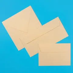 Ein quadratischer, ein klassischer und ein DIN Lang Briefumschlag liegen mit sichtbarer Klebeseite nach oben – Fokus auf die unterschiedlichen Verschlussklappen.