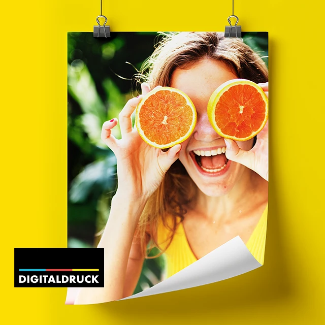 Fotocollage Poster mit Foto einer lachenden Frau und Orangen, aufgehängt mit Klammern vor gelbem Hintergrund