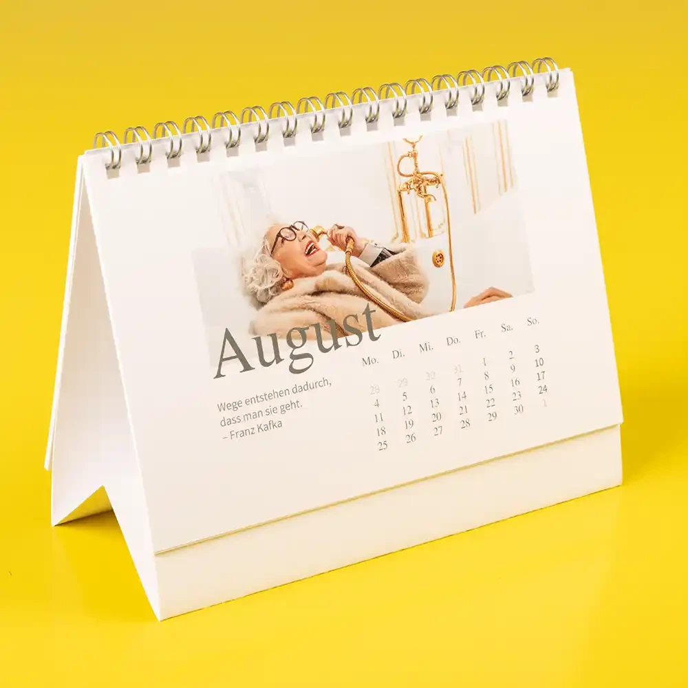 Stehenden Kalender mit Ringbindung selbst gestalten Ein Tischkalender mit Ringbindung, welcher Inspiration für den eigenen Fotokalender zeigt. Wie wäre es mit einem kafkaesken Zitat? Du entscheidest, was abgebildet wird.