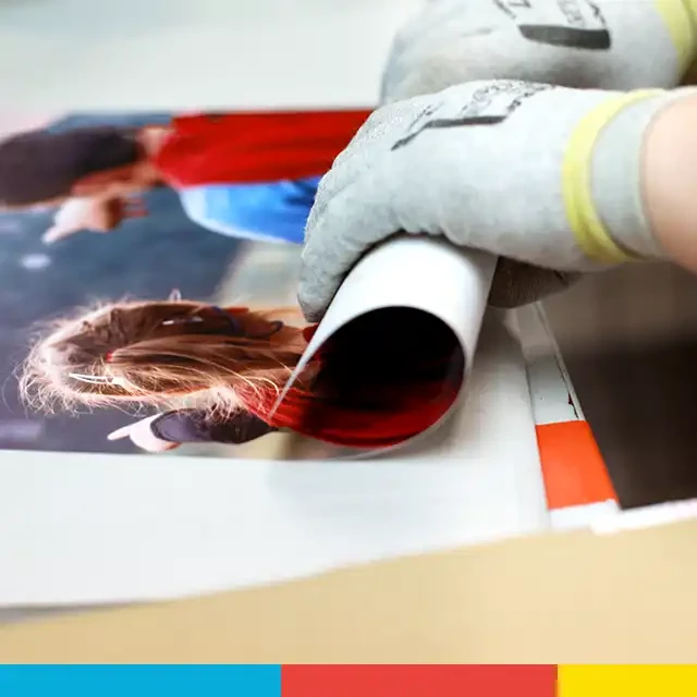 Ein Poster selbst gestalten und bei ORWO produzieren lassen. Sorgsame Hände rollen es zusammen, um es auf den Versand optimal vorzubereiten.