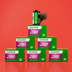 Eine gleichmäßig gestapelte Pyramide aus sieben Fuji Analogfilmen. Sechs Filme sind noch eingepackt und ein ausgepackter Film steht auf der Spitze der Pyramide.