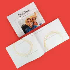 Rechteckiges Gästebuch, welches einmal offen und einmal geschlossen zu sehen ist. Das Buch ist von innen und außen designbar und bietet viel Platz für liebe Grüße.