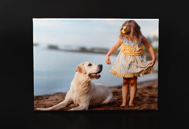 Die Fotoleinwand zeigt ein sommerliches Bild von einem Kleinkind mit einem Labrador am Wasser. Ein einzigartiges Highlight für jedes Zuhause. Auch ohne ORWO Black Week Deals ein super Angebot.