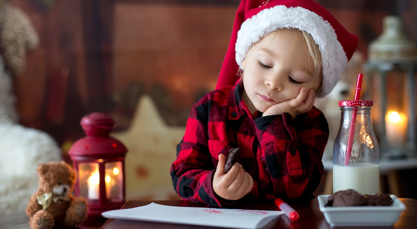 Kleinkind mit Weihnachtsmütze und Brief an den Weihnachtsmann. Fotoideen Weihnachten entdecken.