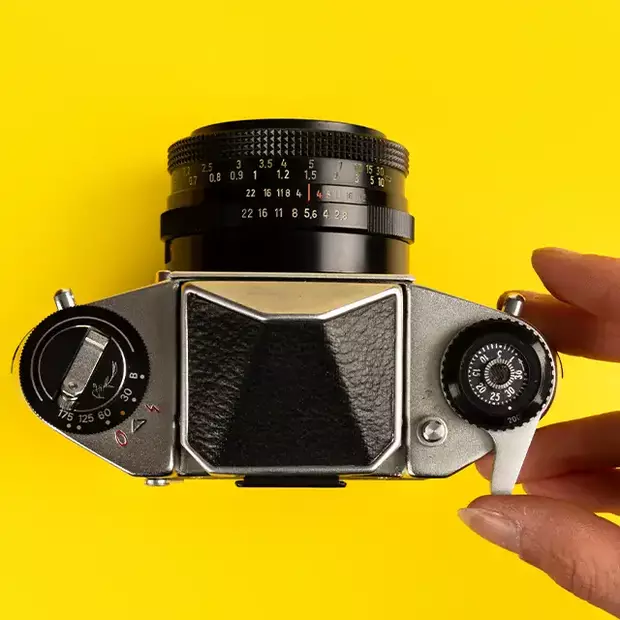 Manueller Filmtransport: Mechanischer Hebel an Analogkamera Eine analoge Kamera wird gezeigt, während der manuelle Filmtransport mit einem mechanischen Hebel durchgeführt wird.