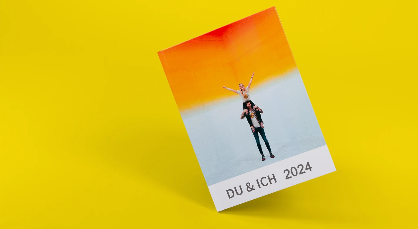 Geschlossenes Fotojahrbuch „Du & ich für immer“ mit Paarmotiv, gelber Hintergrund.