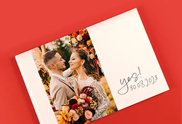 Ein beeindruckendes XXL-Echtfotobuch, dessen Cover ein Foto des Brautpaares mit Brautstrauß und opulenter Blumendekoration zeigt. Dieses Fotobuch bewahrt die schönsten Erinnerungen an den Hochzeitstag und ist ein edles Geschenk oder eine wunderbare Erinnerung für das Paar.