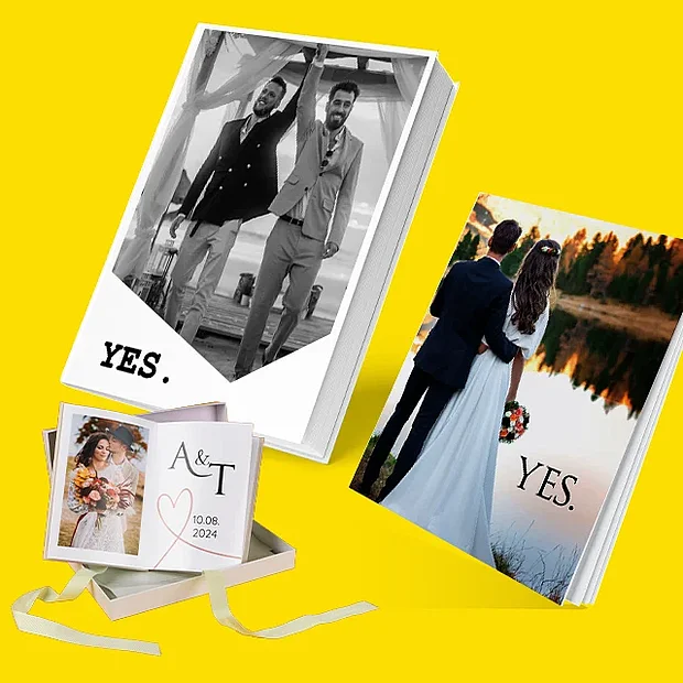 Mehrere Hochzeitsfotobuch Varianten mit Brautpaar auf dem Cover sowie Leporello in Geschenkbox