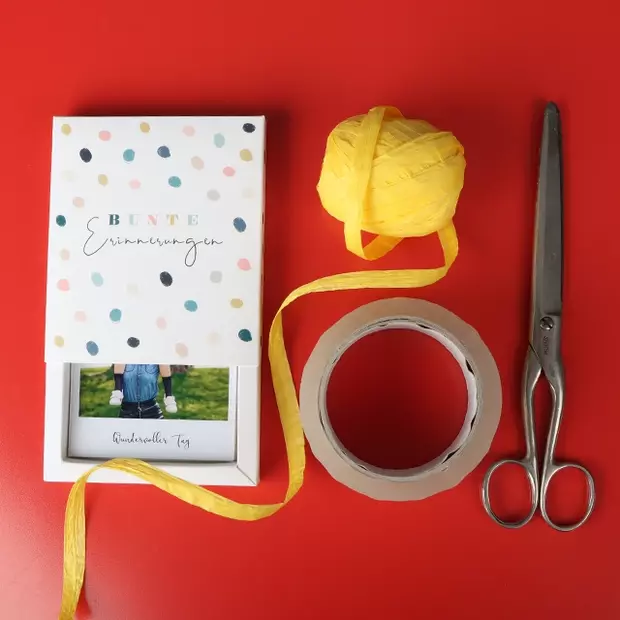 Retrofotos kreativ präsentieren: Das benötigst du Für diesen DIY-Tipp benötigst du nur: eine Schere, Klebeband, Retrofotos, eine Fotobox und Geschenkband