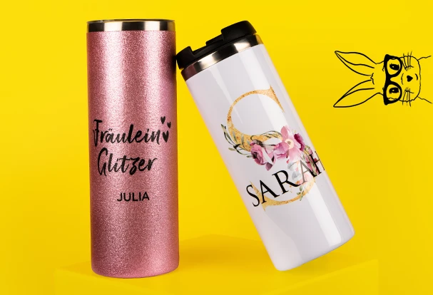 Oster Geschenkideen: Zwei personalisierte Coffee-to-Go-Becher auf gelbem Hintergrund. Einer in Glitzer-Rosa mit dem Namen Julia, der andere in Weiß mit floralem Design und dem Namen Sarah.