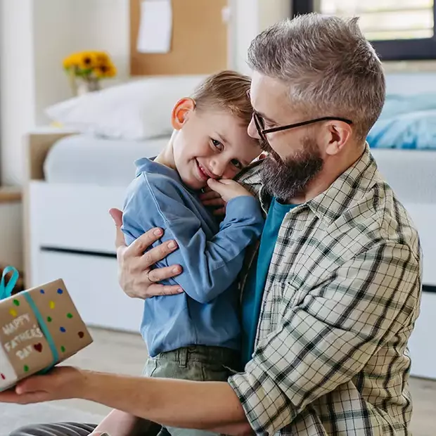 Geschenküberraschung am Vatertag – süße Fotoideen zum Nachmachen Kind überrascht den Papa mit einem Geschenk am Morgen – perfekte Fotoidee zum Vatertag.