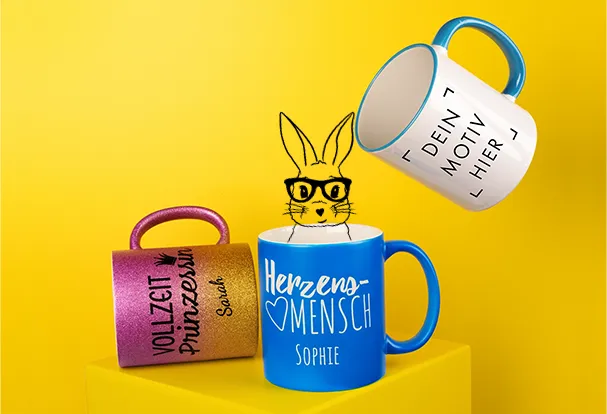 Liebevoll bedruckte Fototassen in verschiedenen Designs: glitzernde Oberflächen, komplett farbige Außenseiten oder Tassen mit buntem Rand und Henkel. Diese personalisierten Ostergeschenke sind perfekte Oster Geschenk Ideen, um Freude und Farbe zu verschenken.