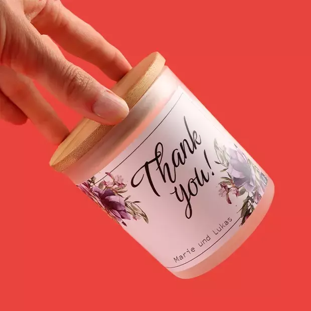 Fotogeschenke Hochzeit: Duftkerze mit persönlichem Druck Eine elegante Duftkerze im Glas mit Holzdeckel, personalisiert mit dem Druck „Thank you! Marie und Lukas“. Diese Duftkerze ist ein charmantes und duftendes Dankeschön, das den Hochzeitstag auf besondere Weise in Erinnerung behält.