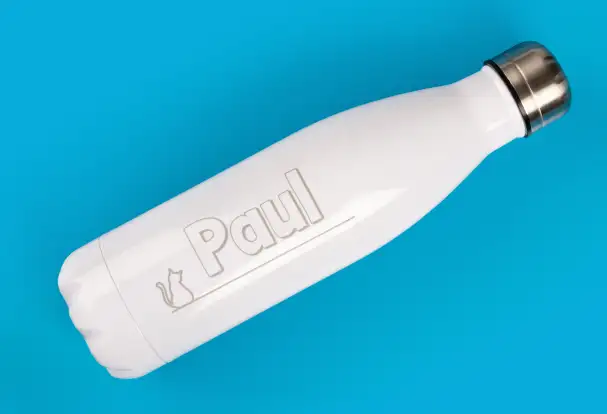 Eine weiße Thermosflasche, liegend, graviert mit dem Namen „Paul“ und einer verspielten Katzengrafik. Dieses gravierte Geschenk ist ideal für Katzenliebhaber und sorgt für praktische und stilvolle Begleitung im Alltag.