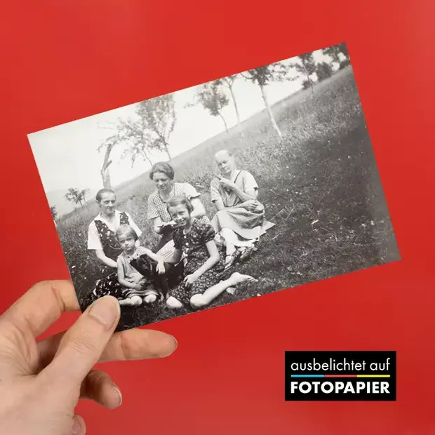 Ein neu entwickelter Schwarz-Weiß-Abzug auf Echtfotopapier wird als Bild vom Bild in der Hand gehalten.