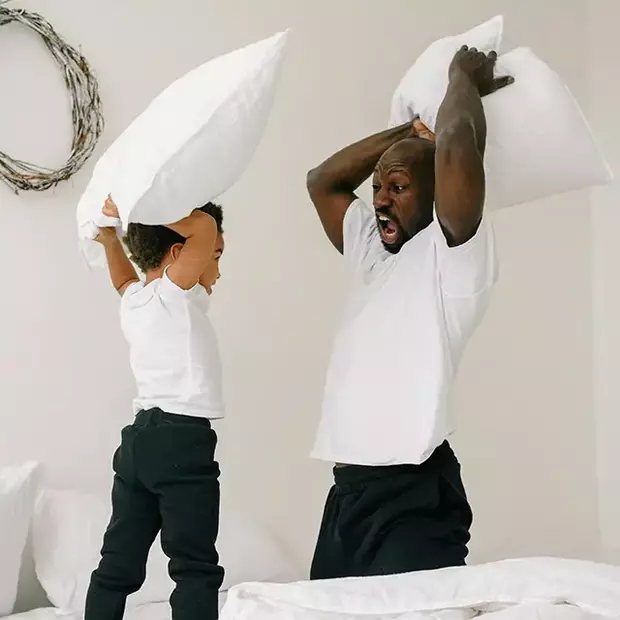 Match’i’match und Kissenschlacht mit Papa – Fotoideen Vatertag Vater und Kind liefern sich eine wilde Kissenschlacht – ein Highlight unter den Fotoideen Vatertag.