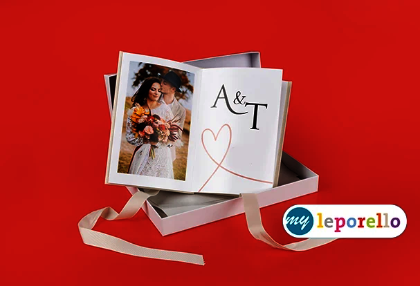 Hochzeitsfotobuch als Leporello in Geschenkbox mit Brautpaar und personalisiertem Cover mit Initialen auf rotem Hintergrund