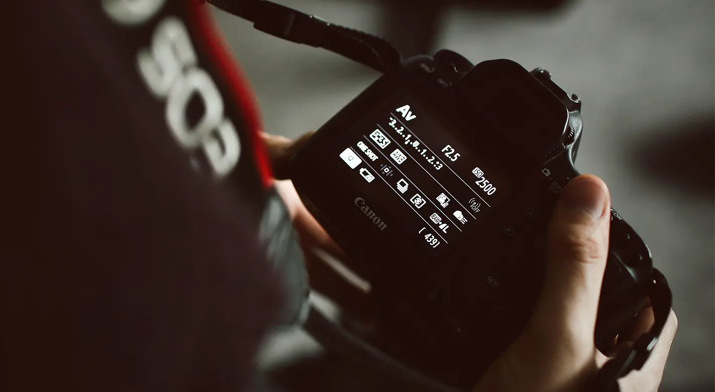 Detailaufnahme einer Spiegelreflex-Kamera, auf deren Display verschiedene Kameraeinstellungen Fotografie zu sehen sind. ORWO hilft die diese zu verstehen.