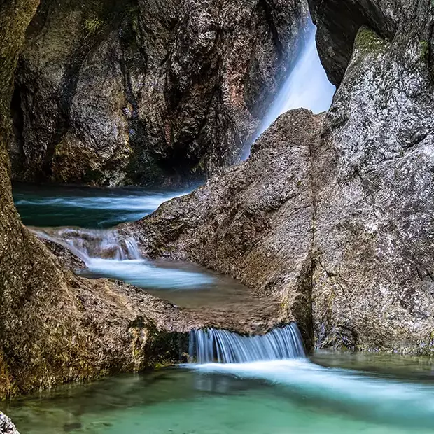 Wasserfall in der Almbachklamm – Magie der Langzeitbelichtung Die Almbachklamm im Berchtesgadener Land: Ein kleiner Wasserfall wird durch den Einsatz eines ND-Filters seidig weich abgebildet – ideal für Naturfotografie.