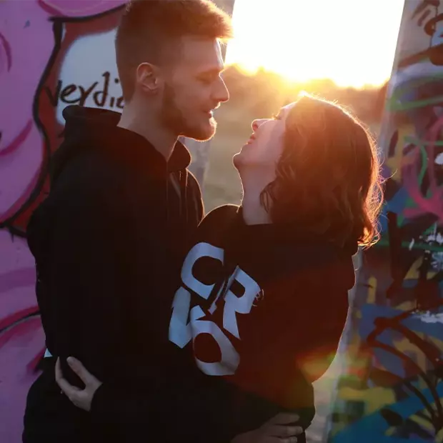 Haltet Blickkontakt für intime Pärchenfotos Ein Pärchen hält Blickkontakt, lacht herzlich und zeigt damit seine tiefe, innige Verbindung zueinander.
