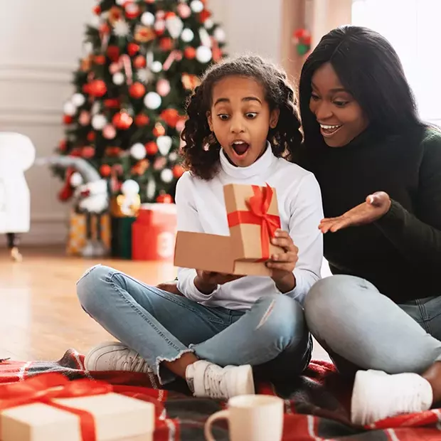 Pure Freude beim Geschenkeauspacken. Ideal für stimmungsvolle Weihnachtsfotos selber machen.