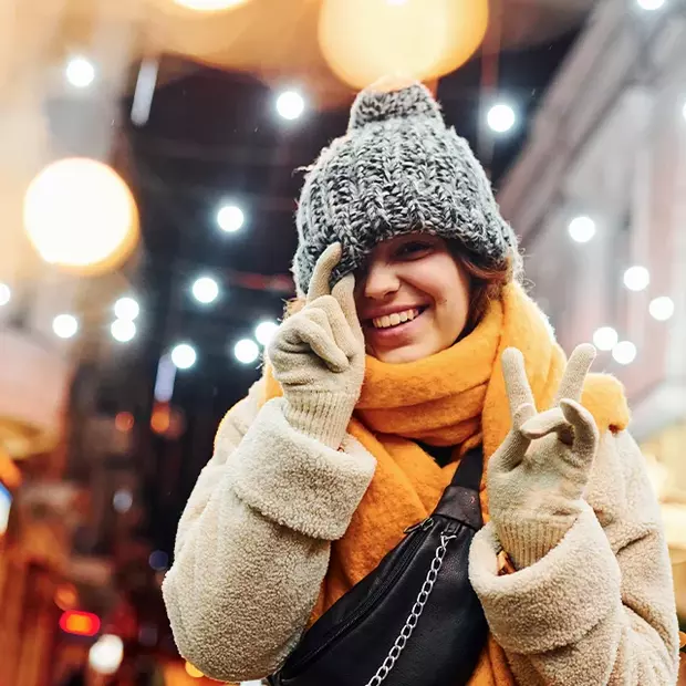 Frau im weihnachtlichen Look umgeben von Lichtern. Fotoideen Weihnachten in festlicher Atmosphäre.
