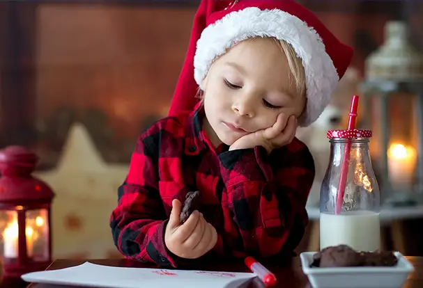 Kleinkind mit Weihnachtsmütze und Brief an den Weihnachtsmann. Fotoideen Weihnachten entdecken.