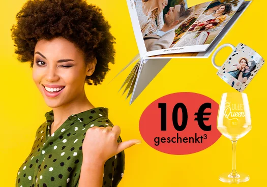 Eine junge Frau im Sommeroutfit vor gelbem Hintergrund zeigt auf unsere Aktion 10 € geschenkt ab 40 € Warenkorbwert. Daneben werden Fotobuch, Fototasse und Weinglas mit Gravur gezeigt. 