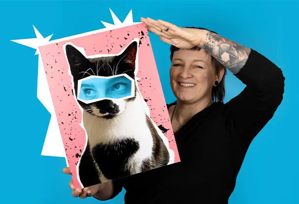 Lachende Frau in schwarzem Shirt hält lächelnd ein großformatiges Foto hoch. Bestelle deine einzigartige Wanddeko bei ORWO.