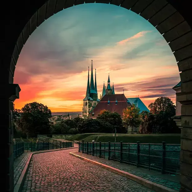 Erfurt bei Sonnenuntergang – Architektur perfekt in Szene gesetzt Der Dom von Erfurt in abendlicher Stimmung, menschenleer und eingerahmt von einem Torbogen. Mit einem Graufilter wird die Lichtstimmung optimal eingefangen.