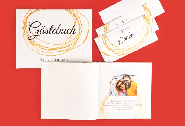 Ein elegantes Gästebuch mit dem Titel „Unsere Hochzeit“ im edlen Gold Brush Design. Die Innenseite zeigt ein Foto des Brautpaares. Neben dem Gästebuch liegen Danksagungskarten im gleichen Design – eine perfekte Kombination für die Hochzeitsvorbereitungen und Erinnerungen.