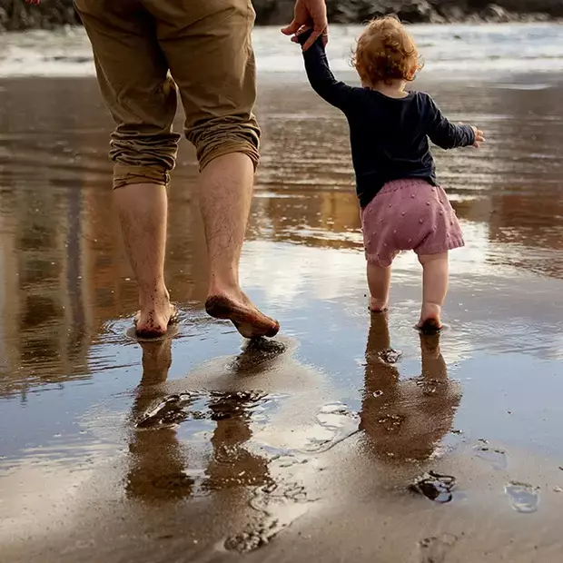 Berührend natürliche Vatertag-Fotos für die Ewigkeit Vater und Kind Hand in Hand am Strand – emotionale Vatertag-Fotos mit Naturkulisse.