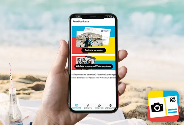 Nahaufnahme eines Smartphones, auf dem die Foto-App geöffnet ist. Der Nutzer gestaltet eine Fotopostkarte mit verschiedenen Bildern und Texten.