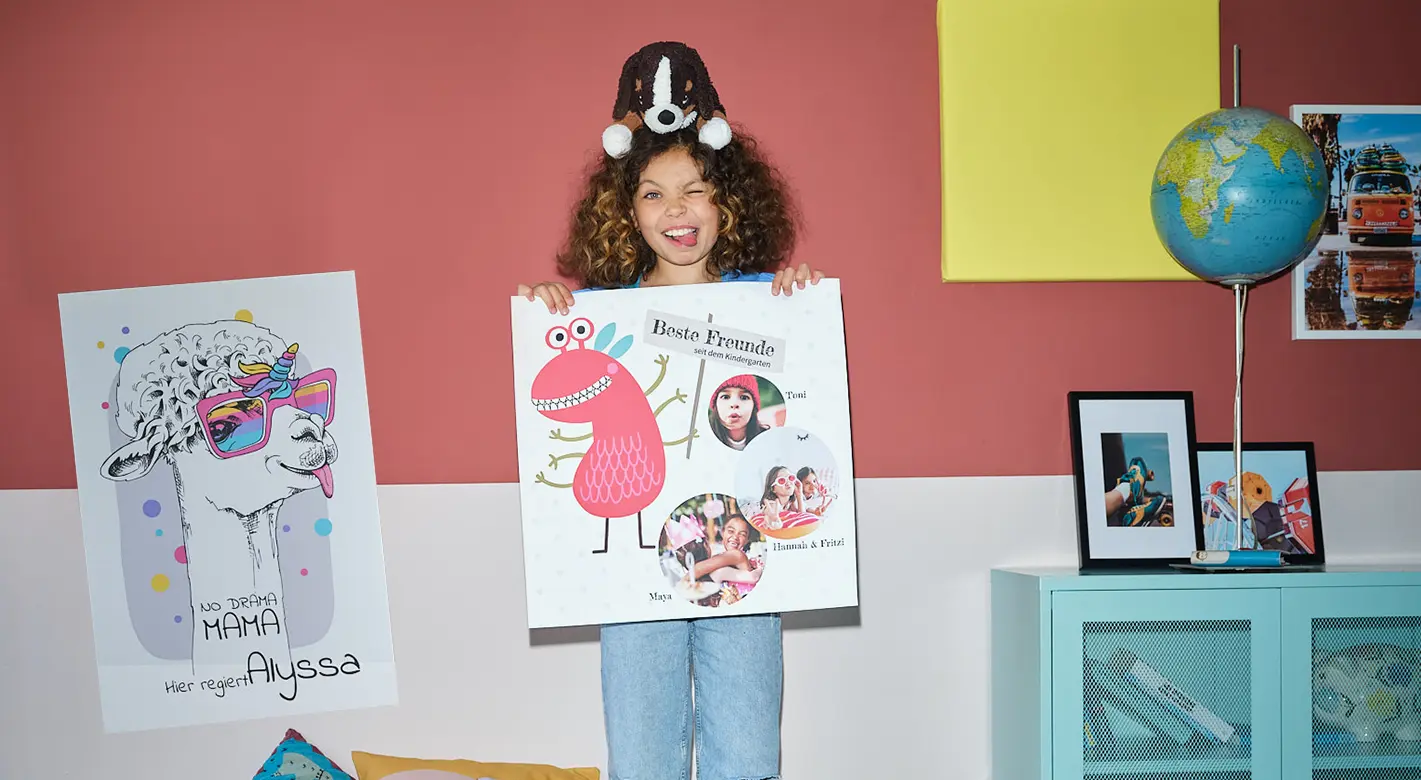 Fotogeschenke für Kinder: Ein lächelndes lockenköpfiges Mädchen posiert im bunten Kinderzimmer mit lustigem Poster 
