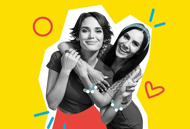 Valentinstag Fotogeschenke für Freunde: Zwei Freundinnen lachen und umarmen sich vor gelbem Hintergrund, modernes Motiv für persönliche Fotogeschenke zum Valentinstag.