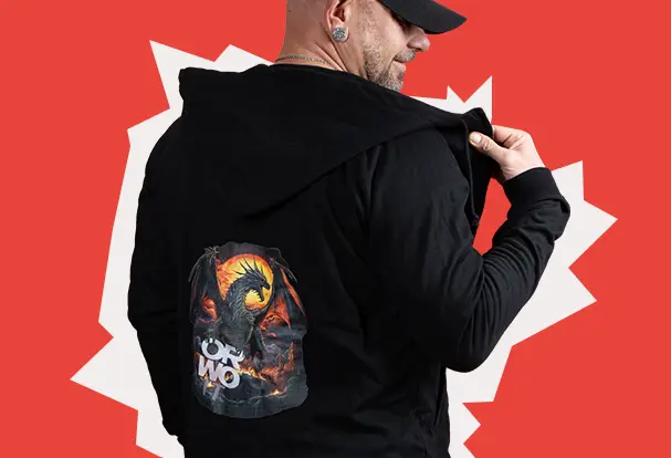 Dennys Lieblingsprodukt: ORWO Sweat Jacke Mann mit schwarzem Kapuzenpullover, der ein Drachenmotiv und das ORWO-Logo auf dem Rücken zeigt, vor einem roten Hintergrund mit weißer Explosiongrafik