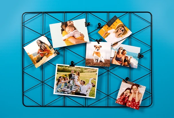 FAQ ORWO Fotoabzüge – Erinnerungen stilvoll präsentieren Klassische Fotoabzüge hängen dekorativ an einem Wandgitter – eine kreative Möglichkeit, deine schönsten Momente festzuhalten.