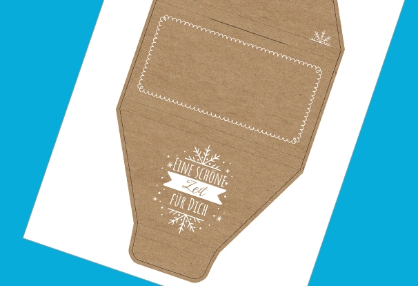 DIY-Bastelbogen „Schneeflocken-Zauber“ – Mit Kraftpapier Schokolade verpacken Der Bastelbogen „Schneeflocken-Zauber“ ahmt braunes Kraftpapier auf der gesamten Fläche nach. Stilisierte Schneeflocken und die Aufschrift „Eine schöne Zeit für dich“ runden das Design ab.
