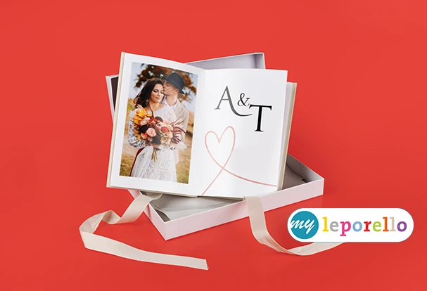 Hochzeitsfotobuch gestalten als Leporello mit individuellem Cover Hochzeitsfotobuch als Leporello in Geschenkbox mit Brautpaar und personalisiertem Cover mit Initialen auf rotem Hintergrund
