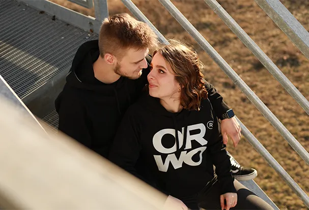 Fotografie-Tipps für Paarfotos im Freien Ein Paar sitzt zusammen auf einer Treppe und genießt den Moment. Hol dir Fotografie-Tipps, um solche besonderen Augenblicke im Freien perfekt festzuhalten!