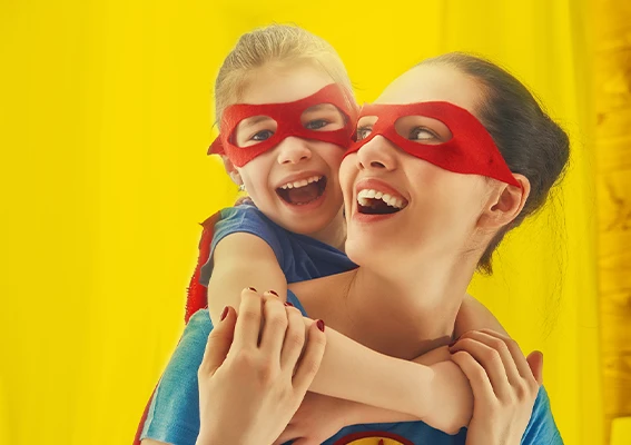 Mutter und Kind mit roten Masken lachen gemeinsam und spielen Superhelden als inspirierende Szene für kreative Fotogeschenke Ideen zum Muttertag mit persönlicher Bedeutung