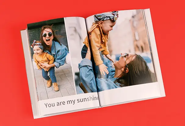 Selbst gestaltetes Fotobuch mit persönlichen Fotos von einer Mutter mit Kind und Spruch.