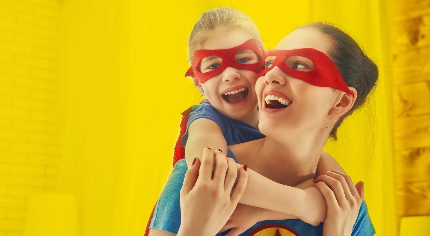 Superhelden-Momente mit Mama Mutter und Kind mit roten Masken lachen gemeinsam und spielen Superhelden als emotionales Motiv für starke Bindung und kreative Fotogeschenke zum Muttertag
