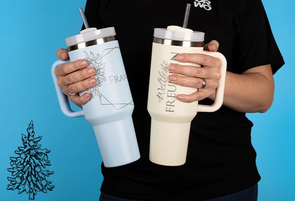 Personalisierte Weihnachtsgeschenke: XXL-Thermobecher mit Gravur Eine Person hält in jeder Hand einen riesigen XXL-Thermobecher mit Gravur. Diese beeindruckenden Thermobecher sind nicht nur praktisch, sondern auch stilvolle Fotogeschenke Weihnachten, die Platz für jede Menge Wärme und Persönlichkeit bieten.