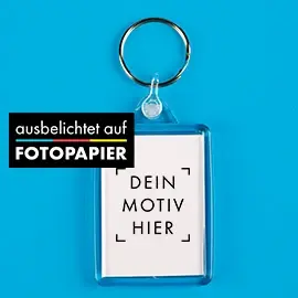 Anhänger aus klarem Acryl mit Platzhalter für deine Gestaltung. Präsentiert vor blauem Hintergrund.