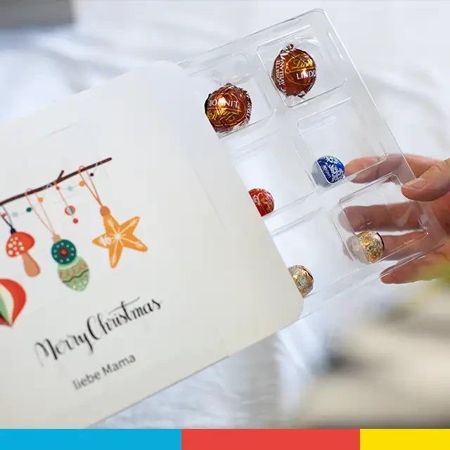 Geöffneter Schokoladen-Adventskalender mit persönlichen Grußbotschaften, hochwertige Produktion.