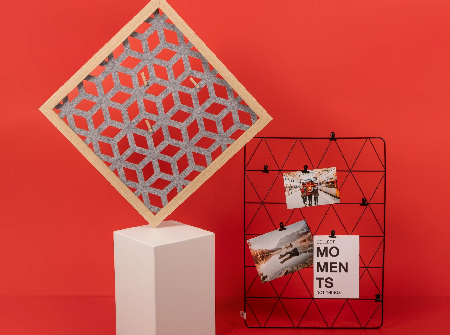 Zwei stehende Fotowände: eine aus grauem Filz im Holzrahmen, die andere aus schwarzem Metallgitter mit angeklipsten Fotos.