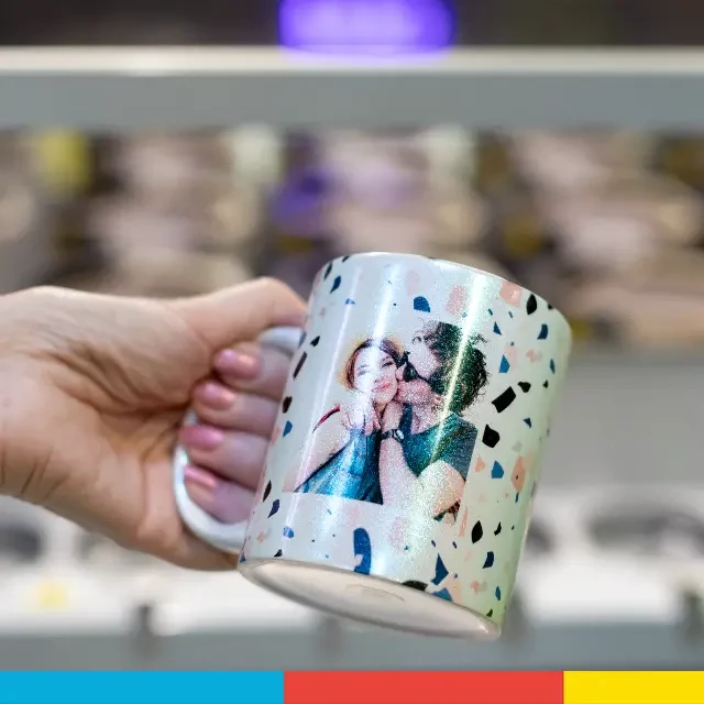 Perlmutt Tasse mit Foto oder Spruch, hochwertig produziert Eine Hand hält die fertig bedruckte Perlmutt Tasse mit Foto oder Spruch. Die Oberfläche der Tasse schimmert im Licht.
