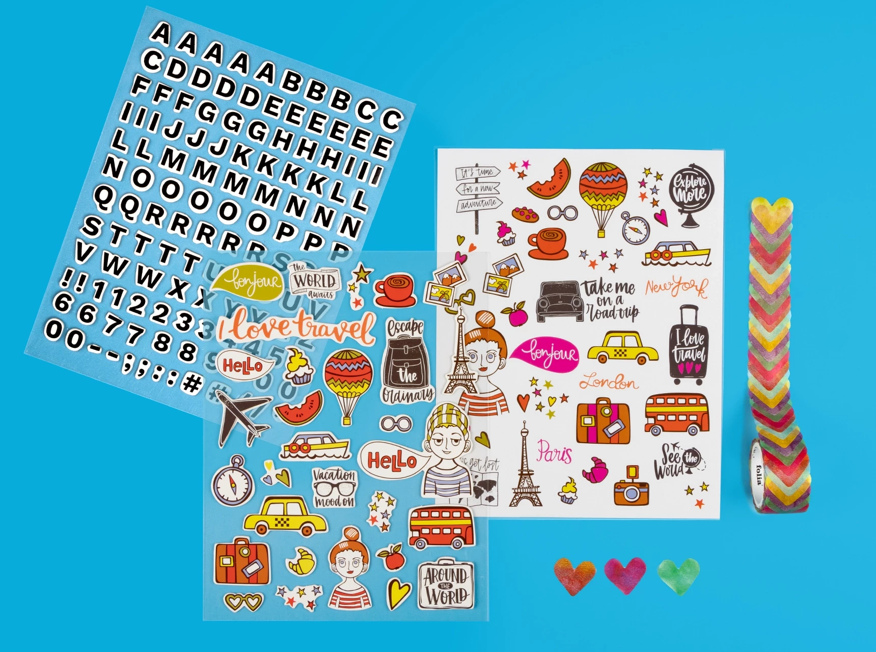 Mehrere bunte Stickerbögen mit Motiven zu Buchstaben, Reisen und Washi Tape, flach ausgebreitet.