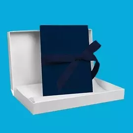 myLeporello in Marineblau – edel & tiefgründig Marineblaues myLeporello mit Schleifenband in Geschenkverpackung. Präsentiert in geöffneter Box vor blauem Hintergrund.